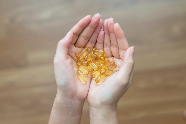 рыбий жир в капсулах в ладонях